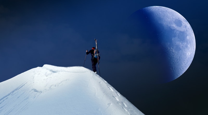 雪山の山頂を登る人